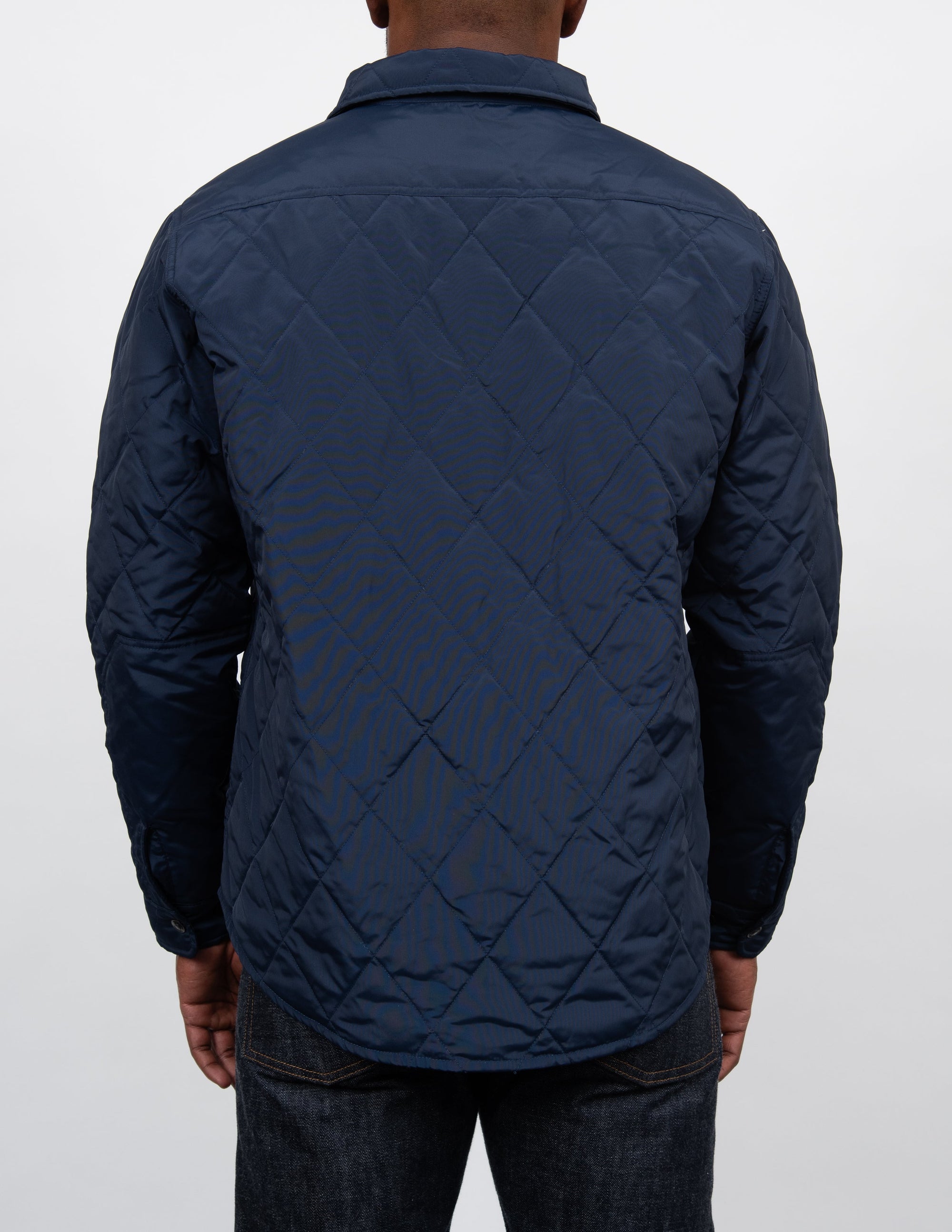 Back view on model of the navy quilted shirt jacket - The Simple Man