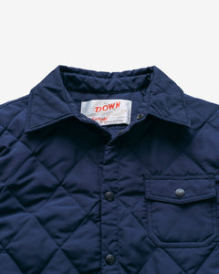 Close-up of the collar, snap placket and chest pocket on the navy quilted shirt jacket - The Simple Man