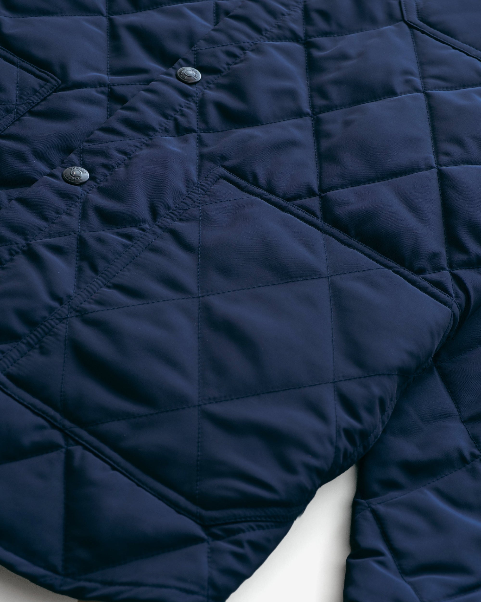 Close-up of the diamond quilting and lower patch pocket on the navy quilted shirt jacket - The Simple Man