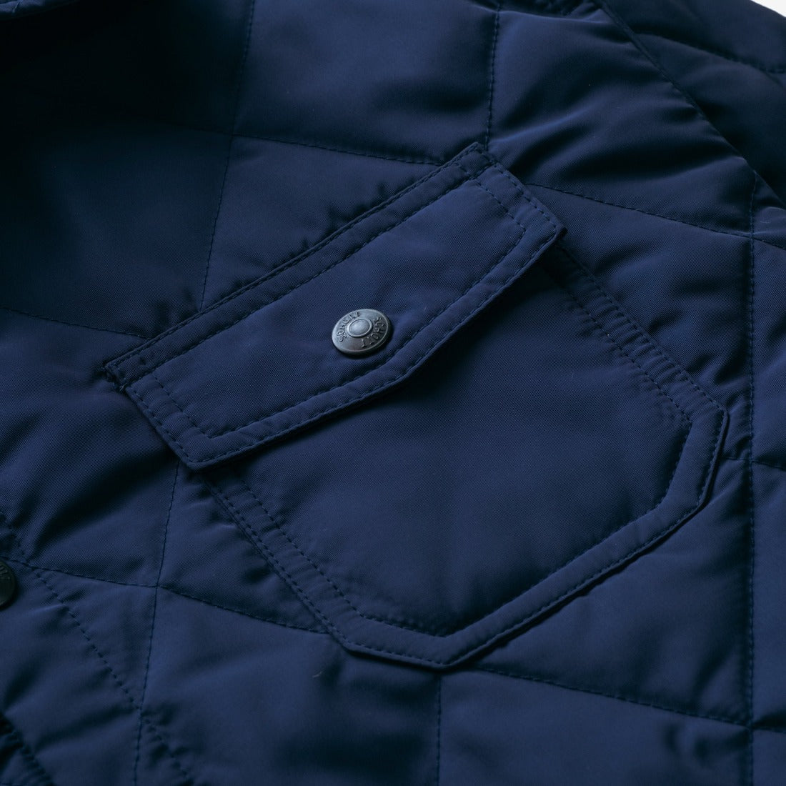 Close-up of the snap chest patch pocket on the navy quilted shirt jacket - The Simple Man