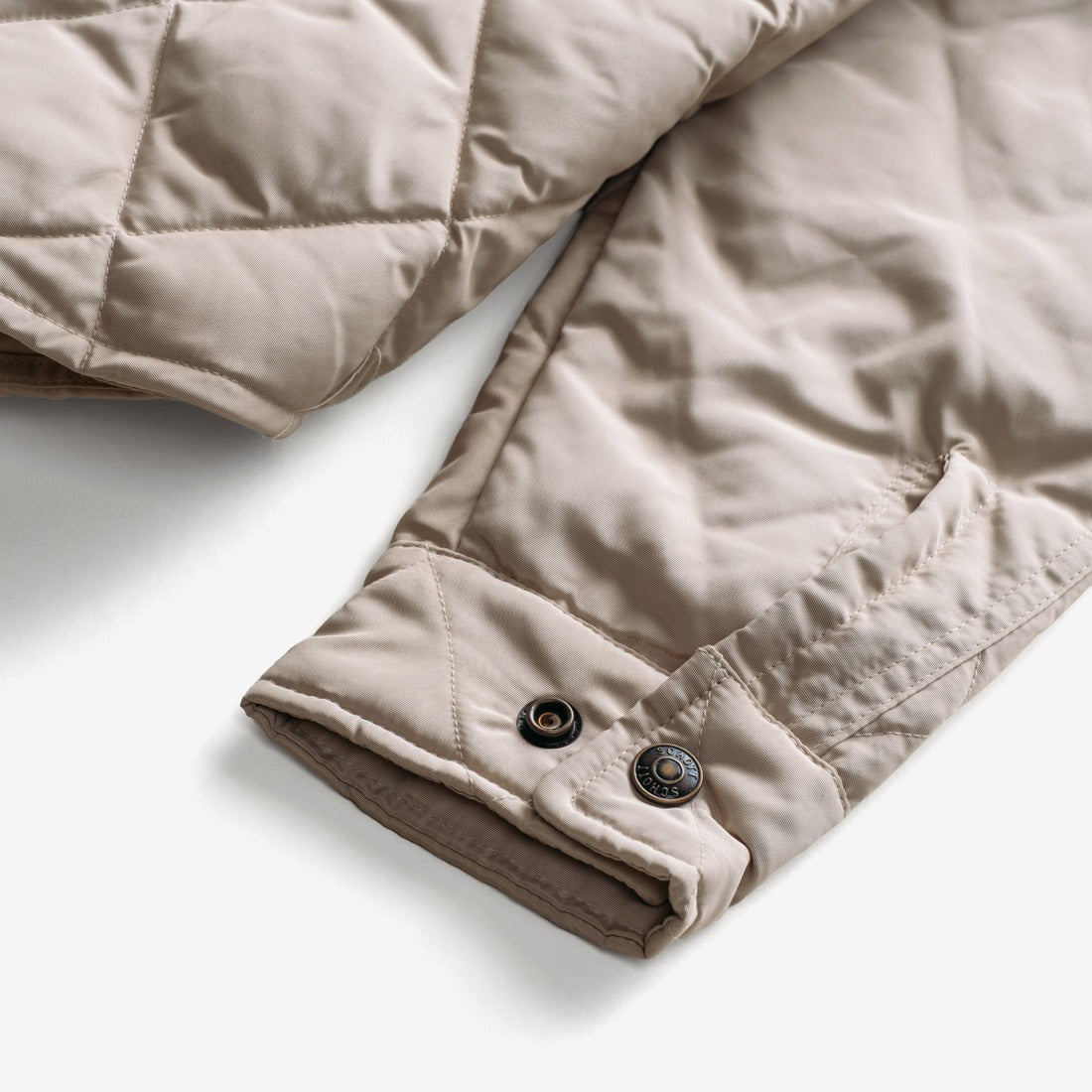 Close-up of the snap cuff on the off white quilted shirt jacket sleeve - The Simple Man