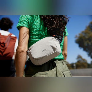 Bellroy Lite Belt Bag in Arcade Grey, worn on the hip by a woman in a green top - The Simple Man