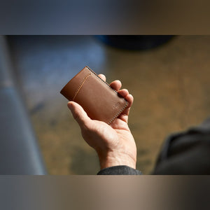 Bellroy Card Sleeve wallet, shown in tan leather and held in one hand - The Simple Man