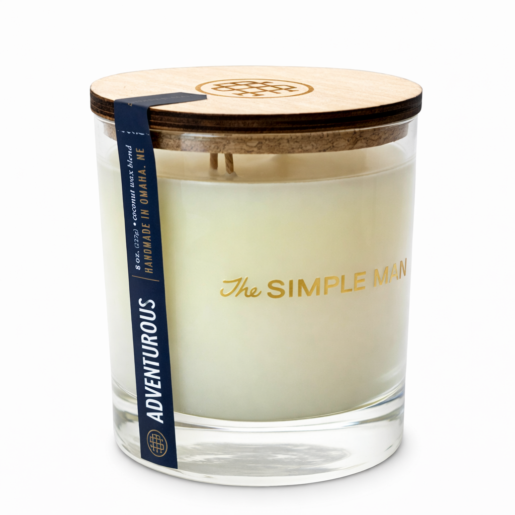 Candle with wooden lid and 'The Simple Man' branding on a white background - Adventurous Lid on