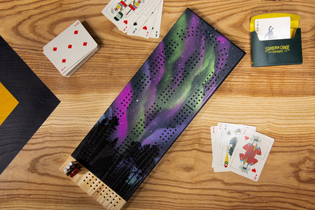 Aurora Borealis cribbage board on table during a game with cards and pegs displayed
