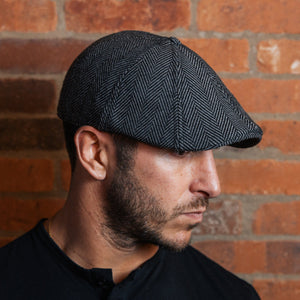 Man wearing the Original Peaky gray herringbone flat cap