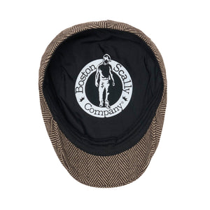 Inside of the brown herringbone scally cap showing black lining and label