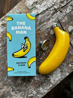A flask that looks and feels like a banana sold with a funnel for filling,  front of packaging