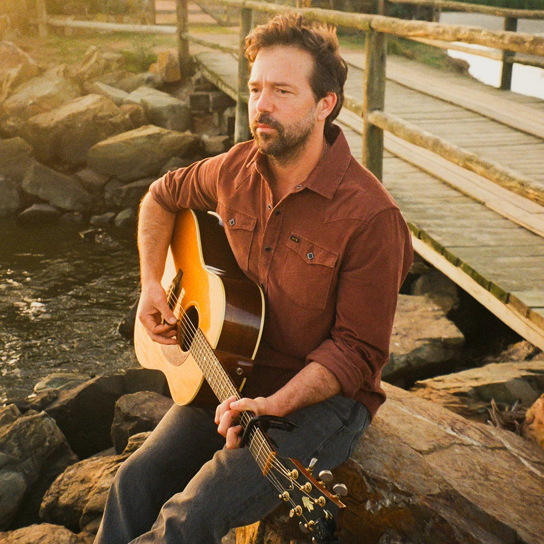 Man playing guitar outdoors wearing the Mink Brown Banning Corduroy Snapshirt, rust brown corduroy western shirt lifestyle shot -- The Simple Man