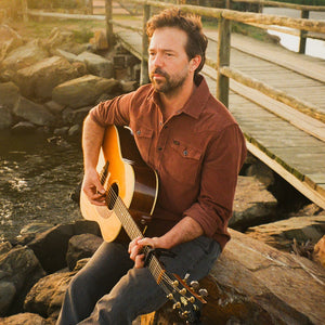 Man playing guitar outdoors wearing the Mink Brown Banning Corduroy Snapshirt, rust brown corduroy western shirt lifestyle shot -- The Simple Man