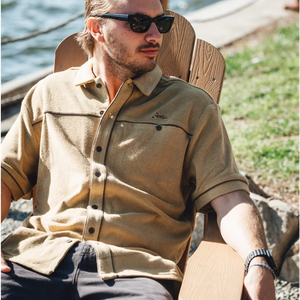 Men’s mustard cotton terry button down shirt styled casually outdoors with black pants and sunglasses