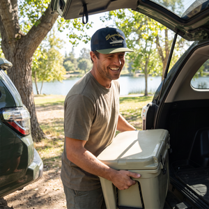 Man wearing navy Boat Crew Hat with olive bill while loading a cooler outdoors - The Simple Man