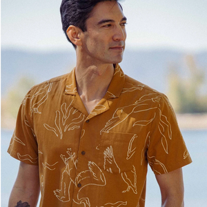 Bridge and Burn Bodie Shirt Shoreflight print amber front view on model near water — men's lightweight camp collar shirt with pelican heron print