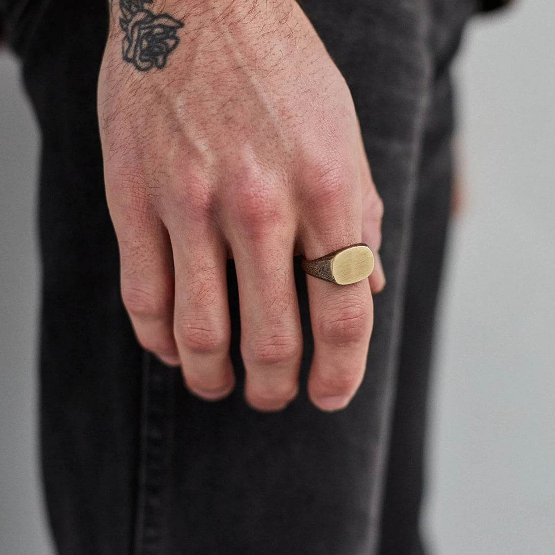 Brass signet ring worn on hand, showcasing brushed face and natural patina – men’s accessories available at The Simple Man