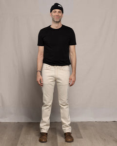 Man wearing Ace Rivington Brodie Taper Jean in Ecru Rinse with black t-shirt and beanie — full front view men's tapered denim