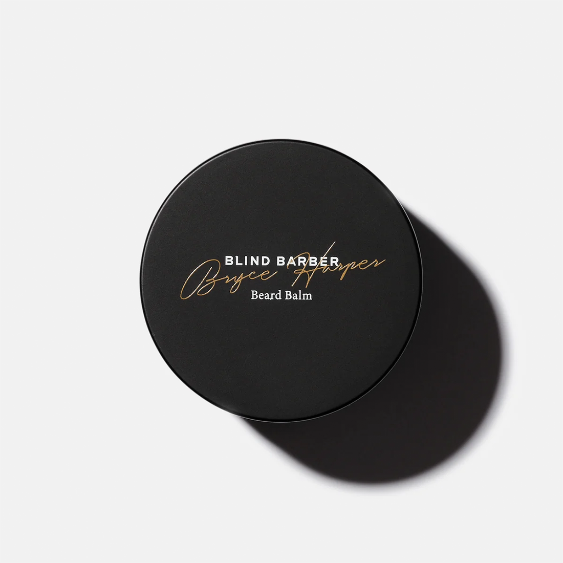 Top view of the black Bryce Harper Beard Balm jar lid with gold script lettering