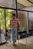 Men's coral multi cotton linen plaid shirt – lifestyle shot on model walking with dog in mid-century modern home interior