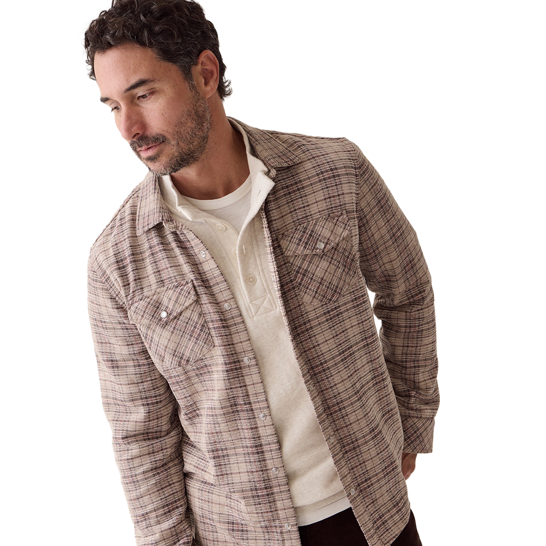 Man looking down in the Clark corduroy shirt in brown plaid, worn open over a cream henley