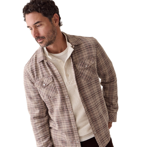 Man looking down in the Clark corduroy shirt in brown plaid, worn open over a cream henley