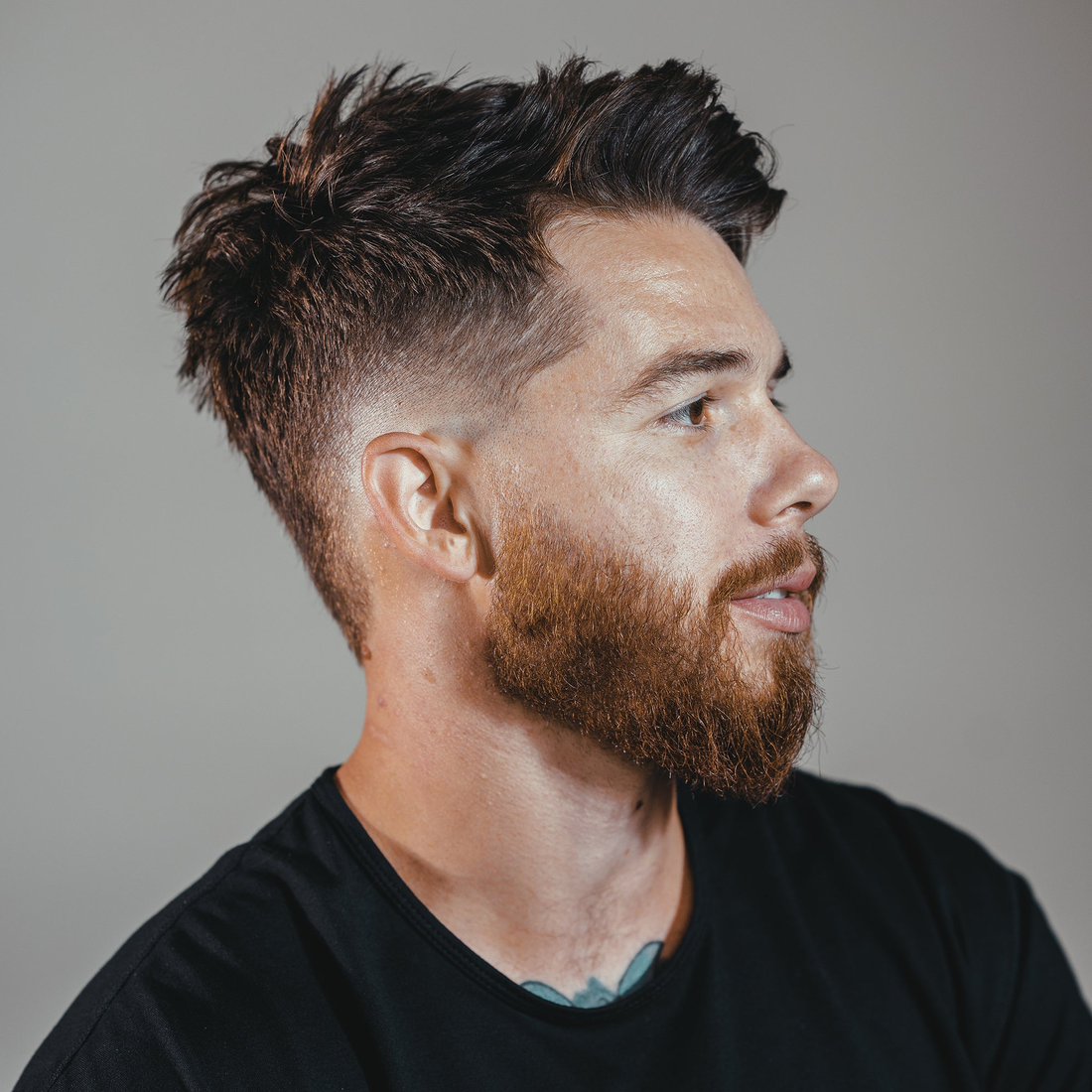 Bearded man in side profile with a textured, tousled top, styled with Claymation