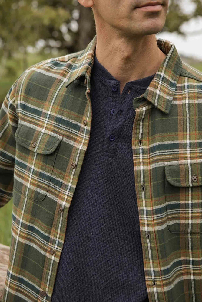 Close-up of The Cole Slim Fit Shirt in Mountain Green plaid worn over navy henley, showcasing soft brushed cotton fabric and dual chest pockets
