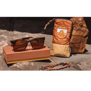 Crag Sunglasses Arches Edition on red rock with box, Arches travel pouch, and paracord retainer
