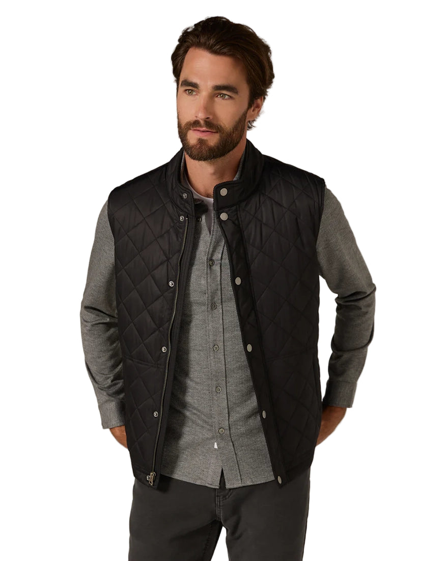 Men's black quilted vest layered over gray shirt – modern water-repellent outerwear from The Simple Man