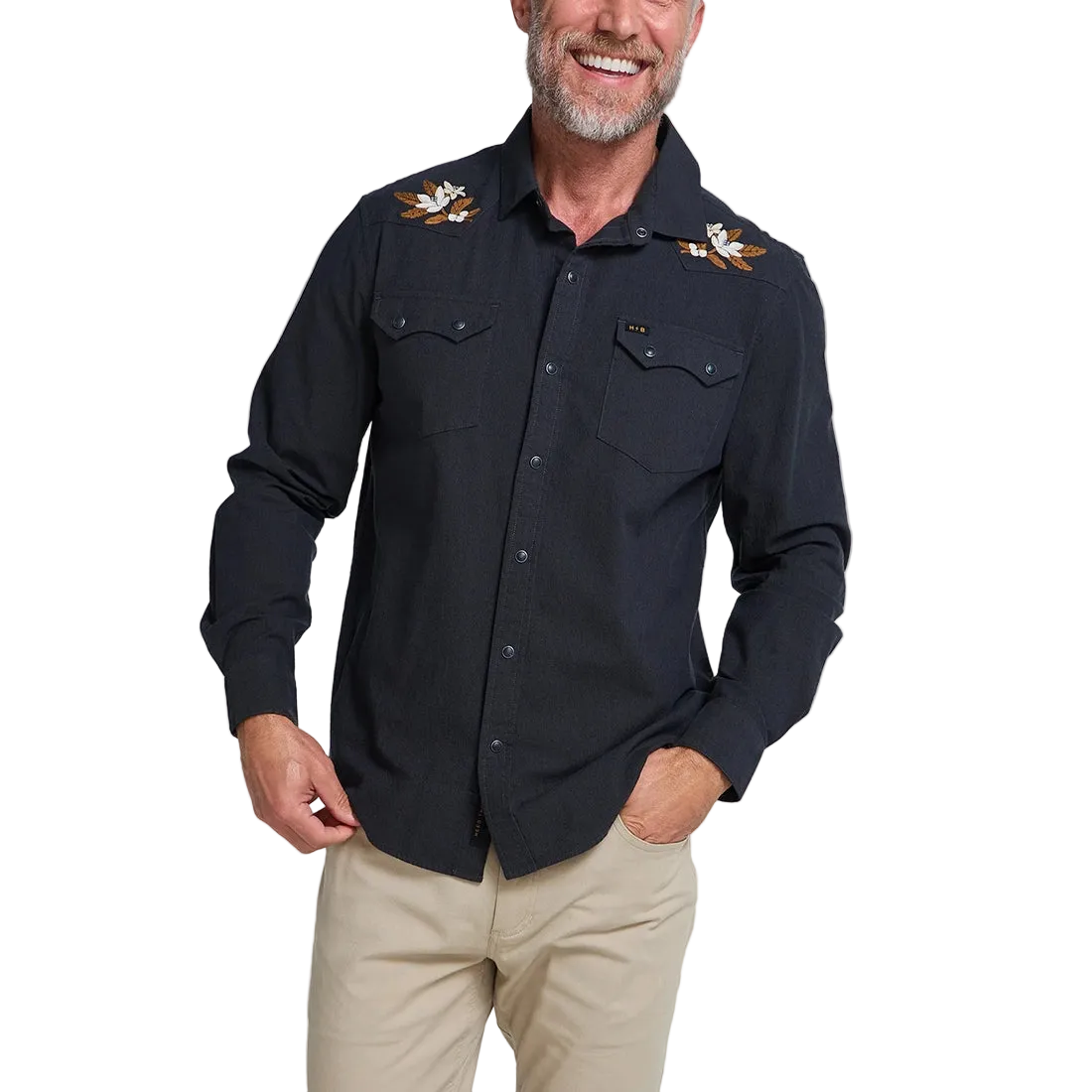 Man smiling wearing the black Orange Blossoms Crosscut Deluxe Longsleeve with embroidered floral shoulder detail, front view -- The Simple Man