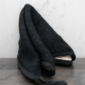 Black dual-sided washcloth folded to show soft and textured sides