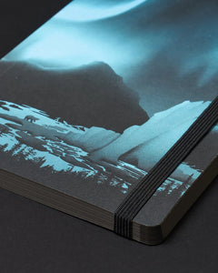 Close-up of Arctic Ice A5 notebook corner showing aurora cover design and elastic strap