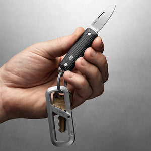 Hand holding The James Brand Elko Black and Fire open on keychain with keys — EDC pocket knife keychain carry titanium ring