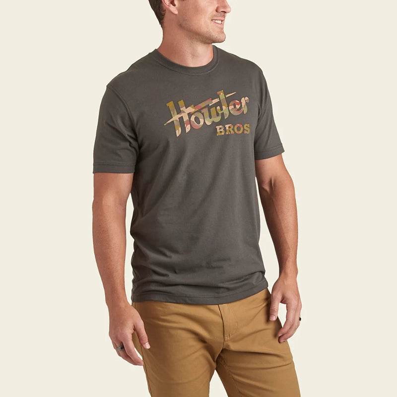 Model Wearing Howler Bros Electric T-shirt with jungle Regime design, front view