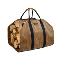Readywares Waxed Canvas Firewood Log Carrier loaded with split firewood — three quarter view showing 39 inch capacity waxed canvas and black webbing