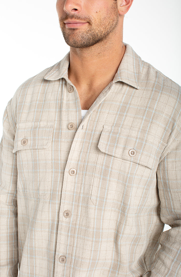 Close up of men’s oatmeal and light blue plaid cotton linen overshirt collar and chest pockets