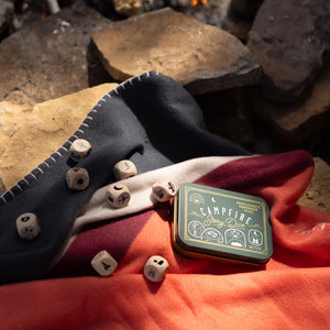 stylized photo showing Gentlemen's hardware campfire story dice in metal tin, front of tin