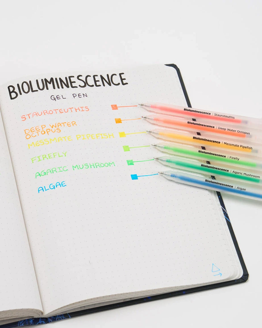 Bioluminescence Neon Gel Pens set writing sample on dotted notebook showing six vibrant ink colors—Stauroteuthis, Deep Water Octopus, Messmate Pipefish, Firefly, Agaric Mushroom, and Algae—from The Simple Man