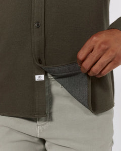 Close-up of Generation Solid Shirt hem and interior fabric texture in olive green