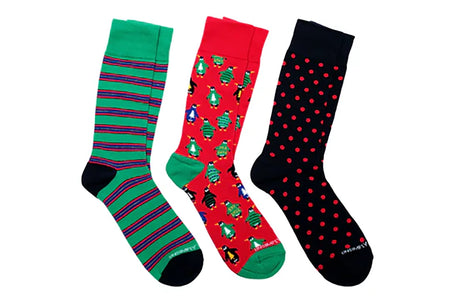 Men’s holiday socks set with green striped sock, red penguin ugly sweater sock, and black sock with red polka dots from The Simple Man