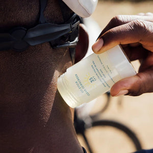 Oars + Alps Go stick Clear Sunscreen stick showing application of product