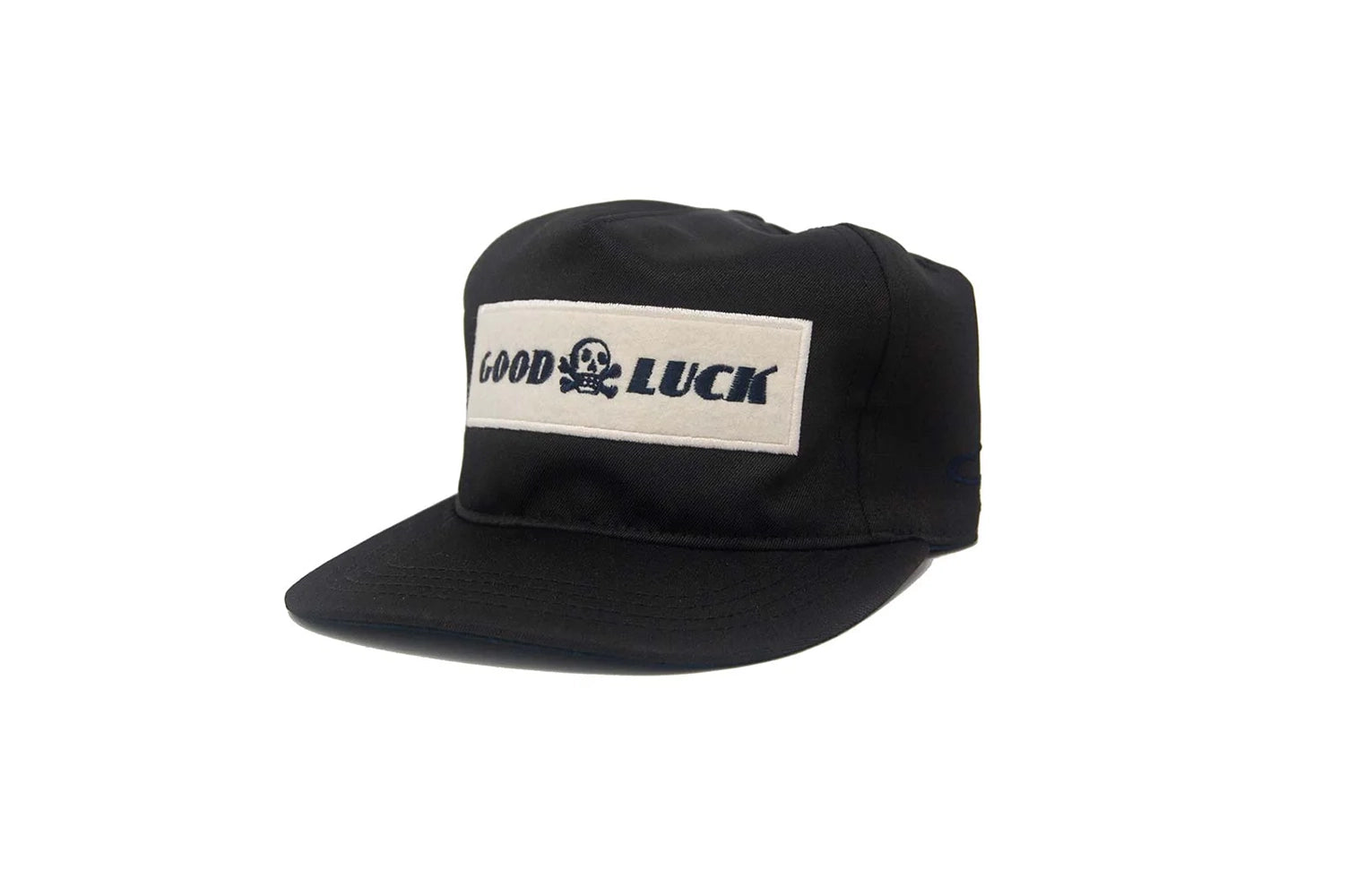 Black Good Luck snapback hat with white felt patch and skull graphic, Ampal unstructured fit, photographed at a front angle for The Simple Man Store.