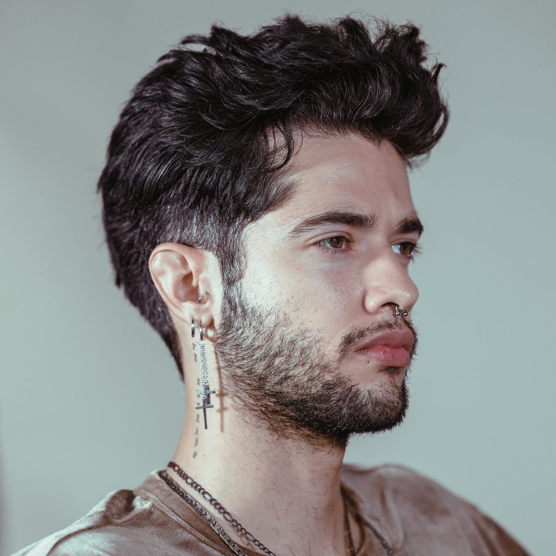 Man with tousled dark hair and a trimmed beard, styled with Gravity Paste
