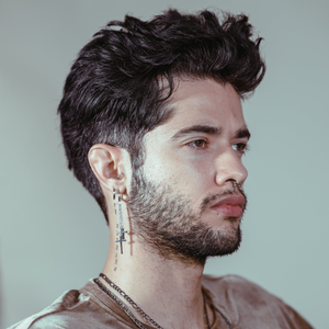 Man with tousled dark hair and a trimmed beard, styled with Gravity Paste
