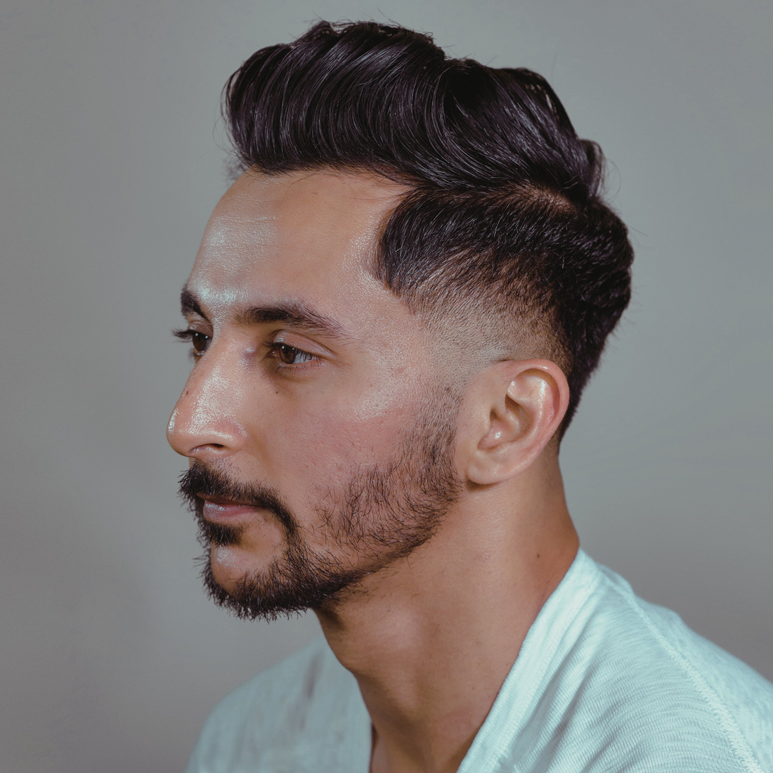 Man in side profile with swept-back dark hair and a short beard, Gravity Paste lifestyle shot