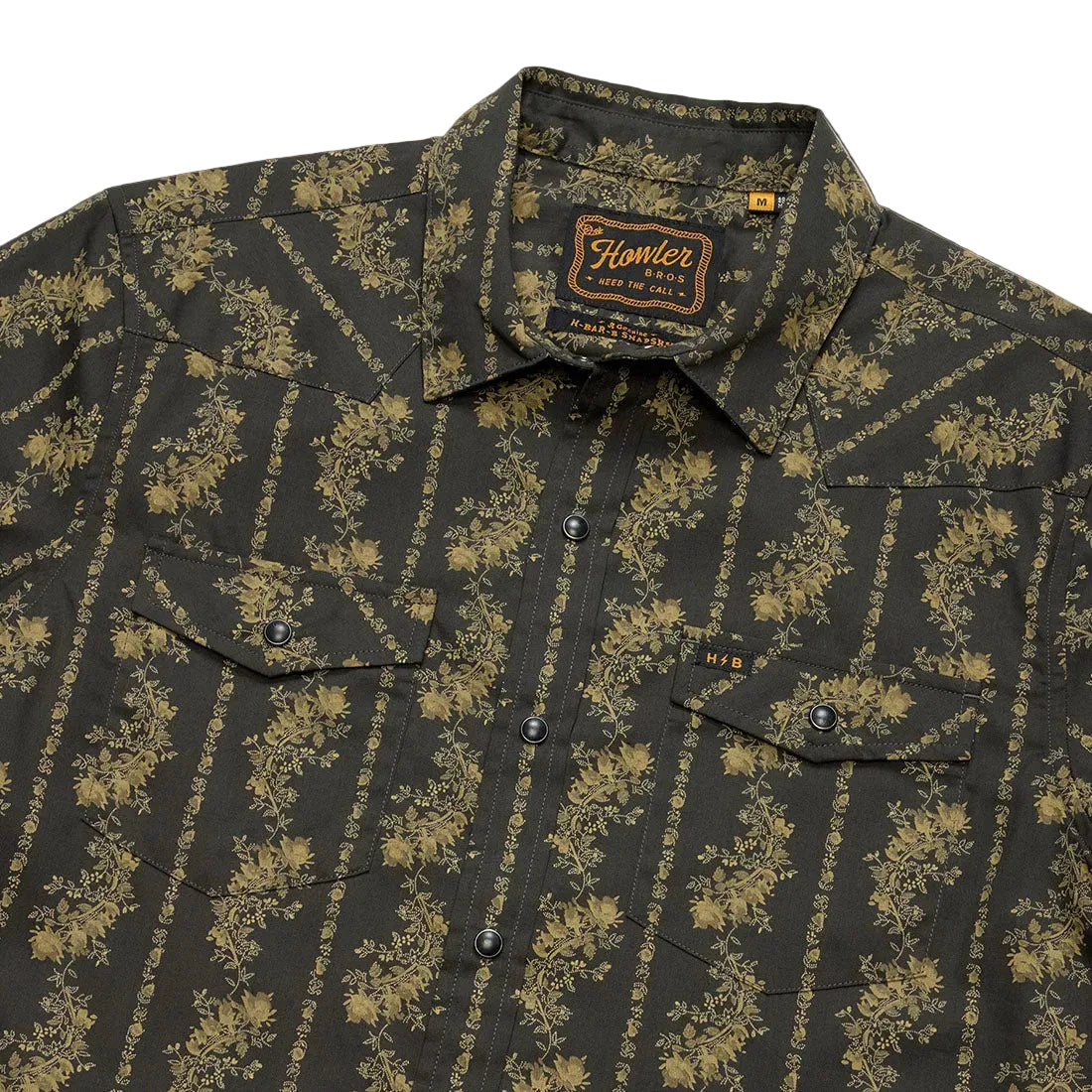 Close-up of collar and chest pockets on the black and olive floral stripe Grampa's Curtains H Bar B Snapshirt showing the Howler Bros label -- The Simple Man