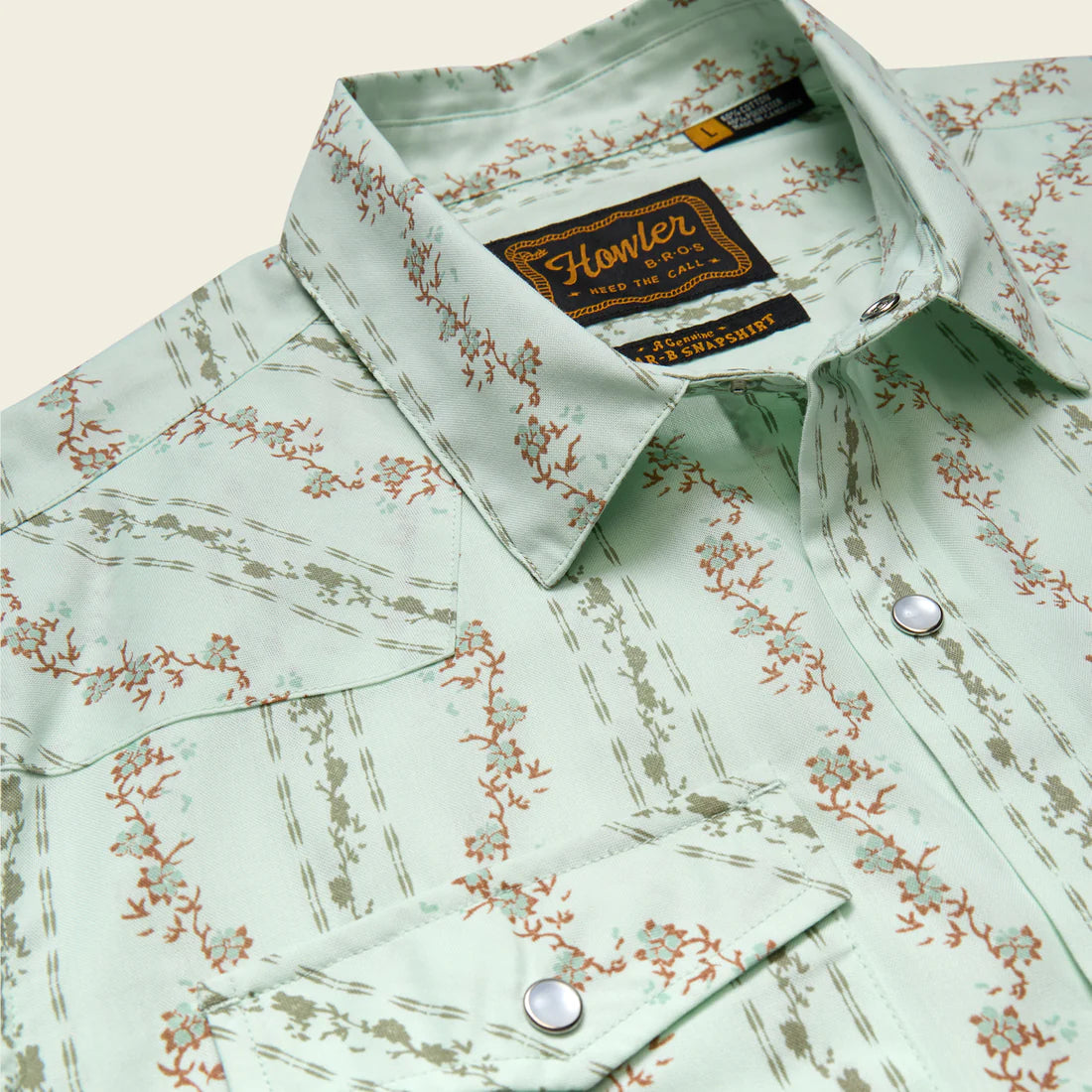 Close up of Howler Brothers H Bar B Snapshirt Mint pearl snap collar and western yoke detail