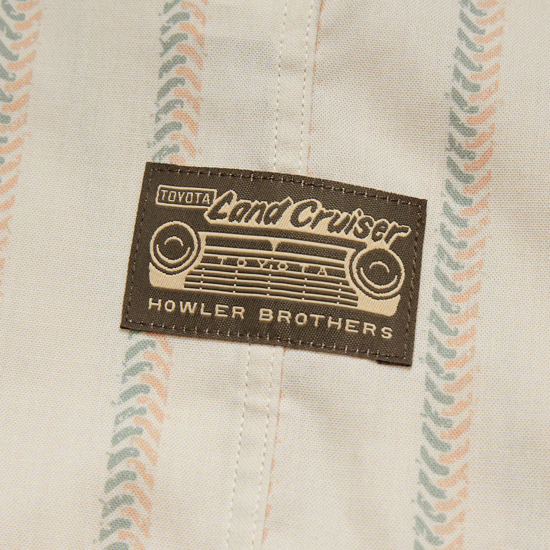 Close-up of Toyota Land Cruiser x Howler Brothers shirt tag on collaborative H Bar B Snapshirt with vintage-inspired stripes