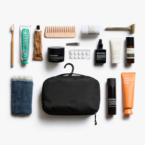 Bellroy black toiletry kit packed with travel essentials, demonstrating flexible soft-sided construction.