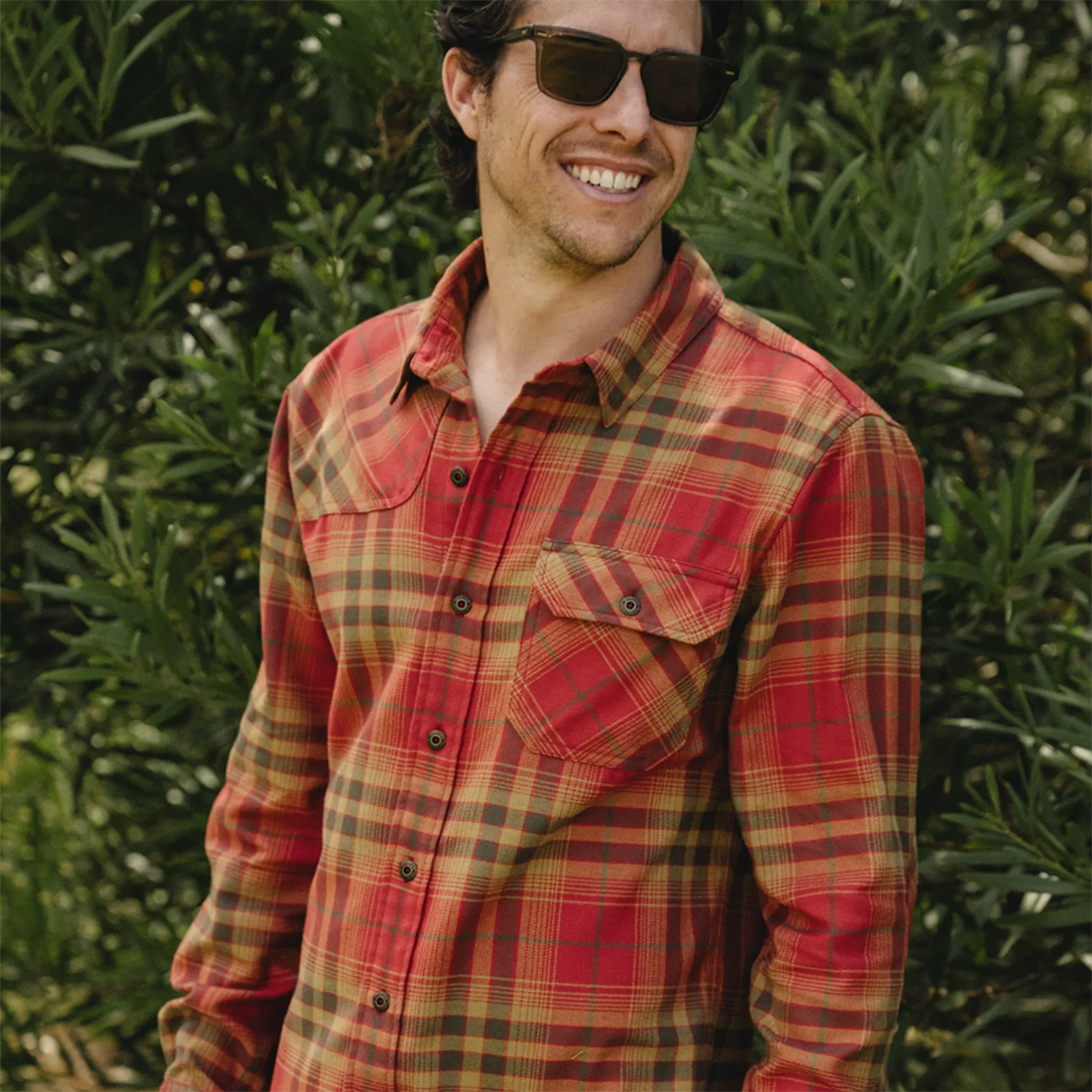 Man buttoning the Kempton Plaid Brick Harker's Flannel over a yellow tee, on model front view, The Simple Man