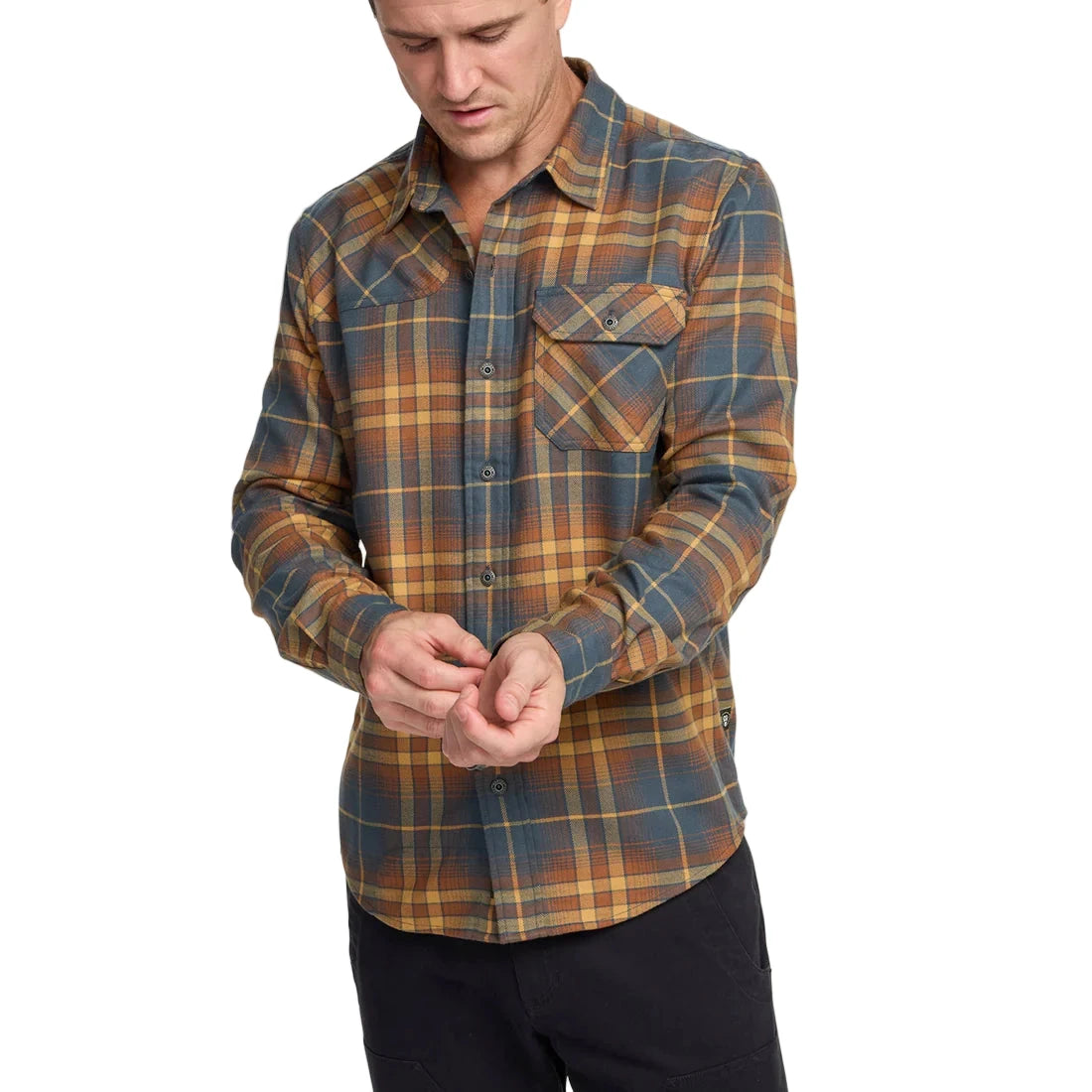 Model wearing Howler Brothers Harker’s Flannel in Kempton Plaid Stargazer adjusting cuff, highlighting chest pocket and classic fit