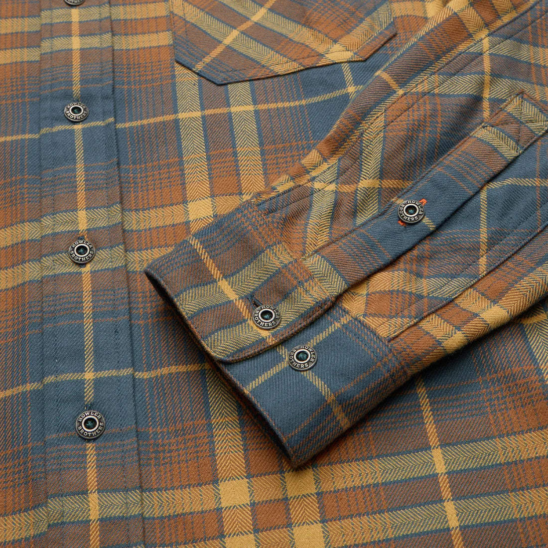 Close-up of Howler Brothers Harker’s Flannel in Kempton Plaid Stargazer showing cuff, custom metal buttons, and soft brushed flannel texture